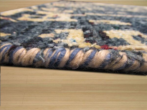 Blue, cream, and red textured rug edge detail showing thick binding threads over light wood flooring.