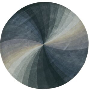 Round rug displays a radial pattern in varying shades of slate blue, dark gray, and light tan wedges.