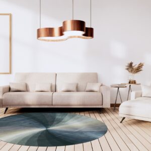 Circular rug featuring a blue and teal gradient sunburst pattern on light wood flooring.