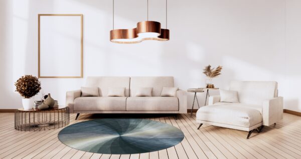 Circular rug featuring a blue and teal gradient sunburst pattern on light wood flooring.