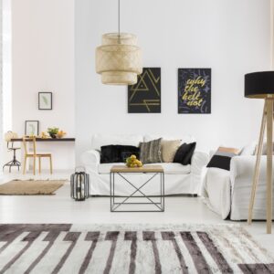 High-pile rug with abstract dark grey and off-white blocks in a contemporary white living room setting.