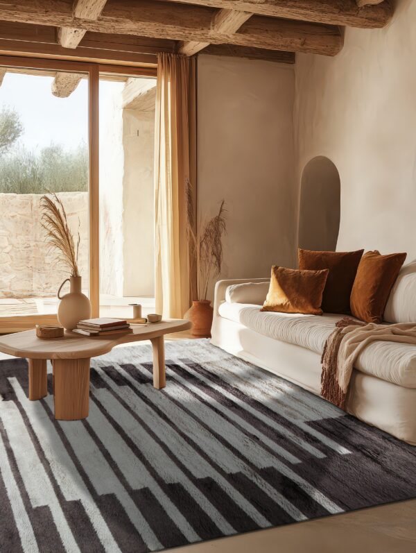 Plush dark gray and white striped rug in a sunny living room with a light sofa and wood beams.