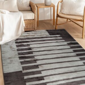Soft gray and dark brown striped rug lying on light wood floor next to wicker and rattan chairs.