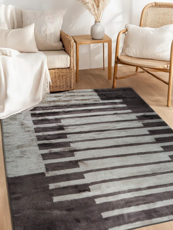 Soft gray and dark brown striped rug lying on light wood floor next to wicker and rattan chairs.