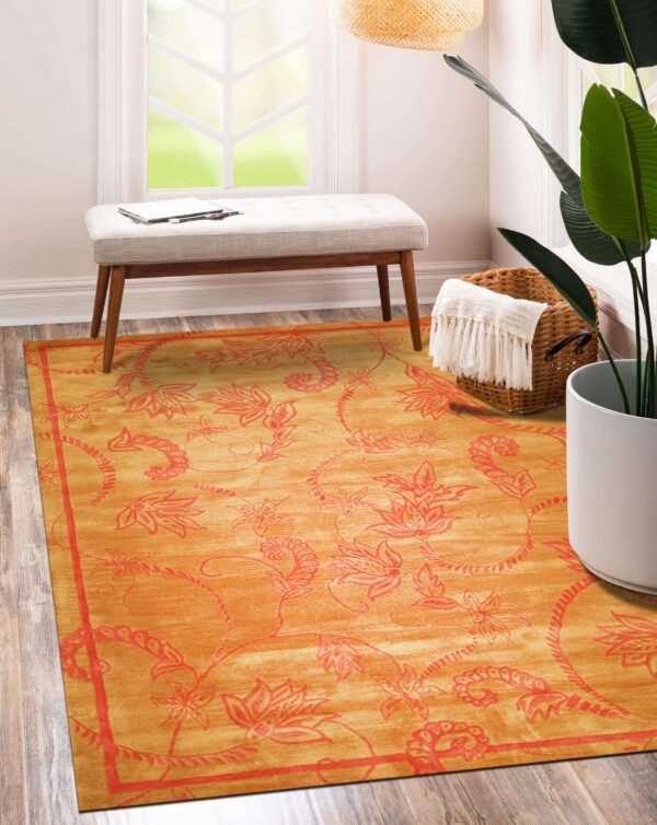 Orange and red botanical rug under a bench in a brightly lit room with wood floors.