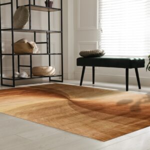 A rust and tan swirling rug anchors a bright room with a black metal shelf and a green velvet bench.