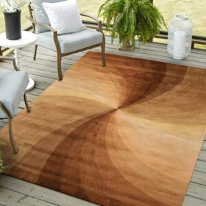 A brown and tan swirl-patterned rug sits on a gray wooden deck with patio chairs and plants.