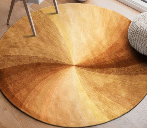 Circular rug with a radial brown and gold swirling pattern rests on a light wood floor.