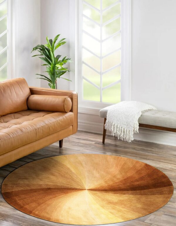 Brown and gold radial gradient round rug in a bright room with a camel leather sofa.