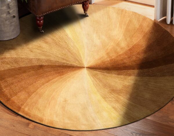 Circular rug in shades of brown and gold displays a radial pattern on hardwood near leather furniture.