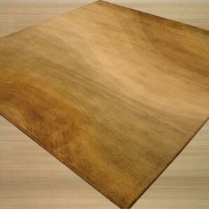 Rectangular gold and brown rug featuring a textured abstract pattern rests on light wood flooring.