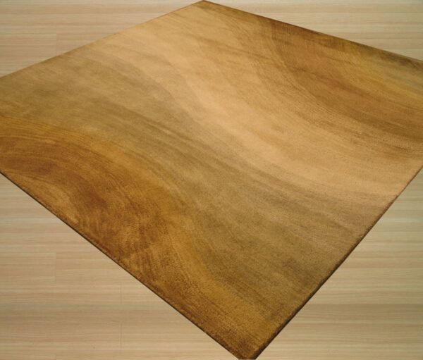 Rectangular gold and brown rug featuring a textured abstract pattern rests on light wood flooring.