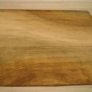 Gold plush rug displaying a subtle swirling pattern rests on light blonde wood planks.