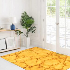 A gold crackle-patterned rug anchors a white entry room with French doors, a console table, and a potted palm.