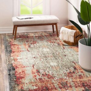 Gray and reddish-orange abstract rug placed under a small upholstered bench on wood plank flooring.