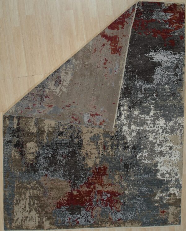Abstract low-pile rug featuring dark gray, beige, white, and red distressed patterns on light wood flooring.