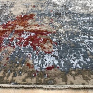 Textured abstract rug in tones of beige, gray, rust, and white on a light wood plank floor.