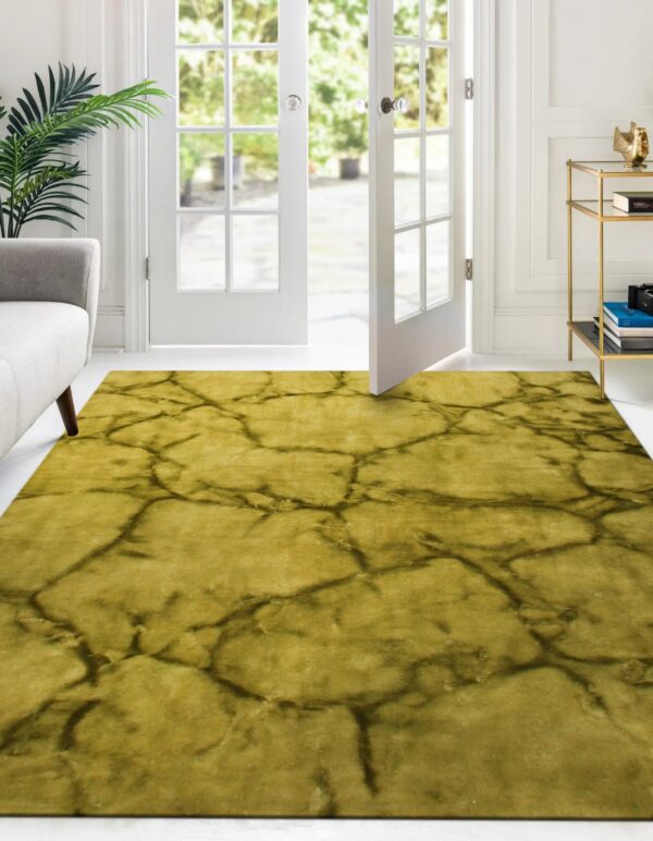 Low-pile yellow rug with dark vein-like pattern in a bright room with white walls and french doors.