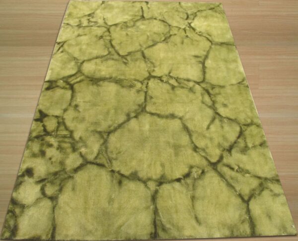 Chartreuse area rug with an irregular dark green crackle design covers a wood floor.