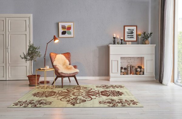 A beige rug with large brown damask patterns anchors a reading nook with an armchair and fireplace.