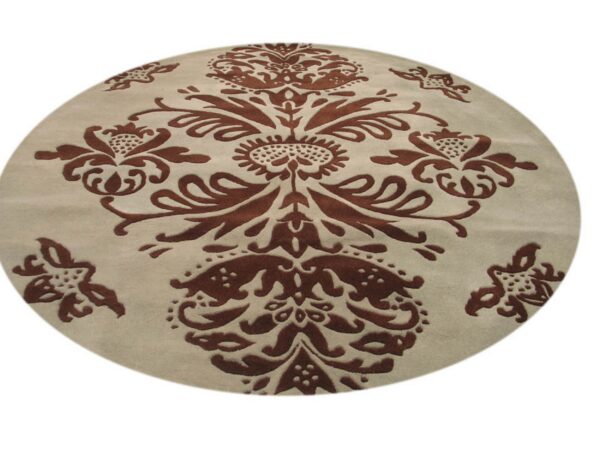 Circular rug with a high-low texture showing a central brown floral motif on beige.