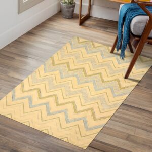 Rectangular yellow rug featuring textured blue and green zigzag lines, set under a wood chair on plank flooring.
