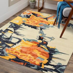 Abstract cream, orange, and navy rug sits on wood planks, partially under a gray armchair.