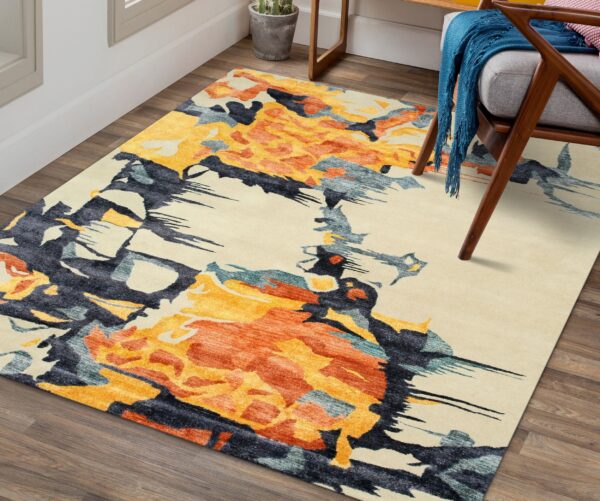 Abstract cream, orange, and navy rug sits on wood planks, partially under a gray armchair.