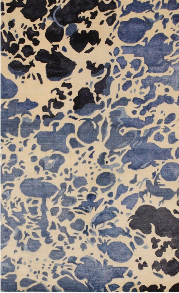 Abstract low-pile rug featuring ivory, light blue, and dark navy organic splotches.