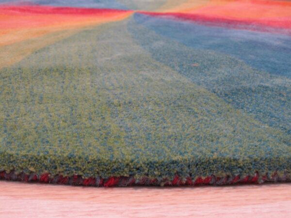 Close view of a dense, multicolored rug pile with green, blue, red, and orange radial sections.