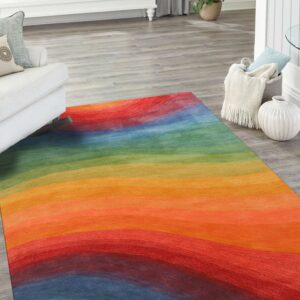 Abstract rug featuring wide, wavy rainbow stripes on light gray wood plank flooring in a bright room.