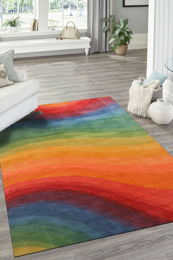 Abstract rug featuring wide, wavy rainbow stripes on light gray wood plank flooring in a bright room.