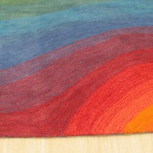 Abstract rug corner showing curved bands of green, blue, red, and orange on light wood flooring.