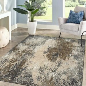 Abstract gray, beige, and brown rug lies under a modern gray chair in a naturally lit room.