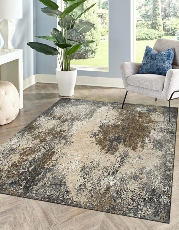 Abstract gray, beige, and brown rug lies under a modern gray chair in a naturally lit room.