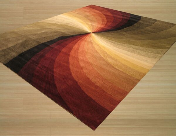 Low-pile rug featuring a radial swirl of red, gold, olive, and black colors sits on light wood flooring.