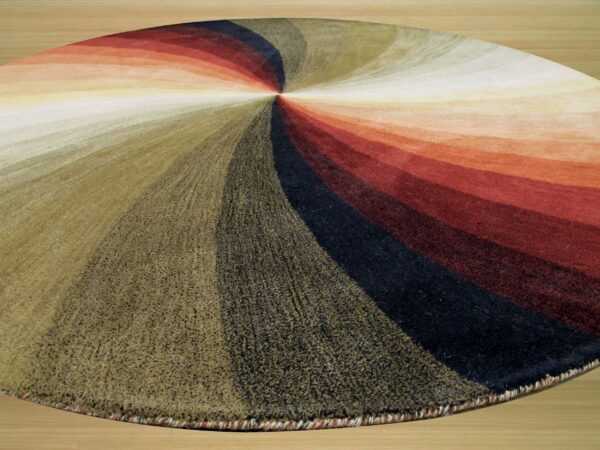 Highly textured round rug displaying bands of olive, red, and black radiating from the center on wood flooring.
