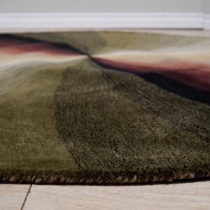 Plush round rug displays dark green, black, and red radiating stripes on light wood flooring.