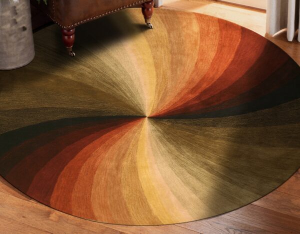 This circular rug displays a radial gradient design in brown, olive, gold, and orange tones on wood floor.