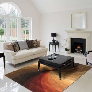 Radial patterned rug in shades of red, orange, and brown beneath a black table on white tile.