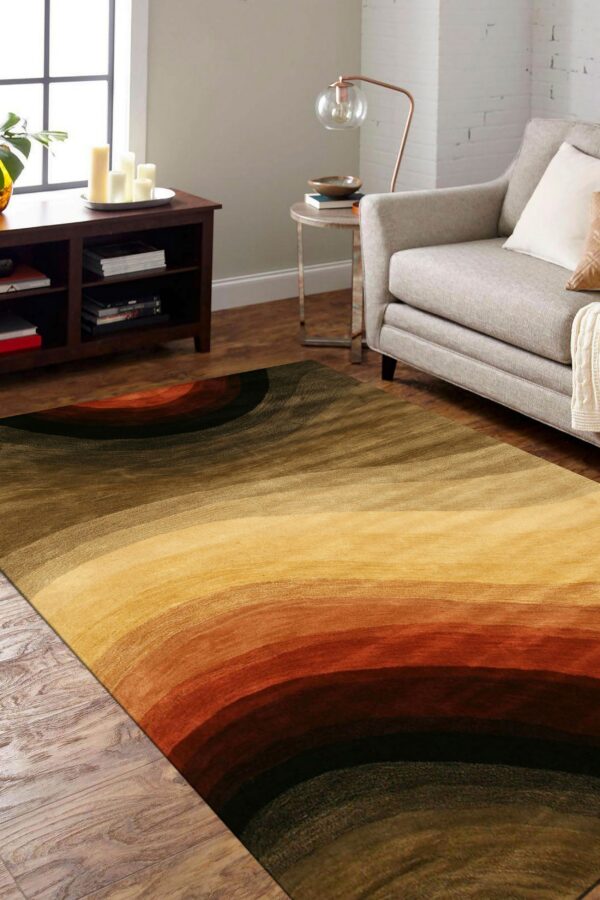 Brown and rust rug with concentric ombre stripes placed beneath a gray armchair on wood flooring.