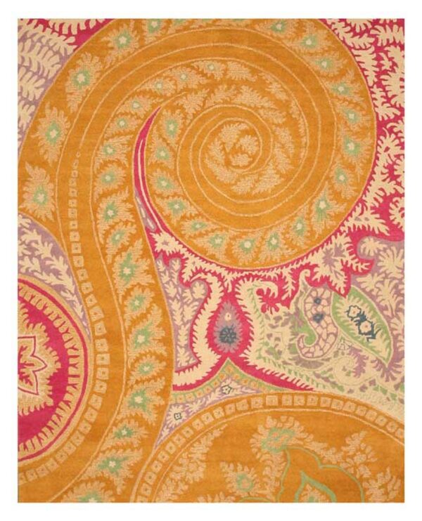 A colorful rug with dense paisley and floral designs in orange, bright pink, cream, and green.
