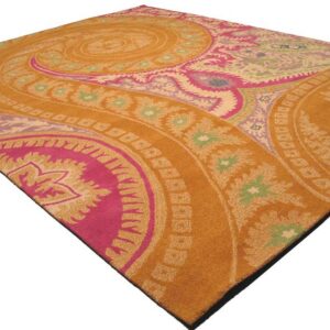 An amber rug featuring a large swirling medallion pattern in bright pink, pale green, purple, and cream colors.