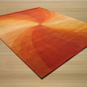 A low pile rug featuring a swirling pattern of orange, red, and yellow rests on light wood plank flooring.