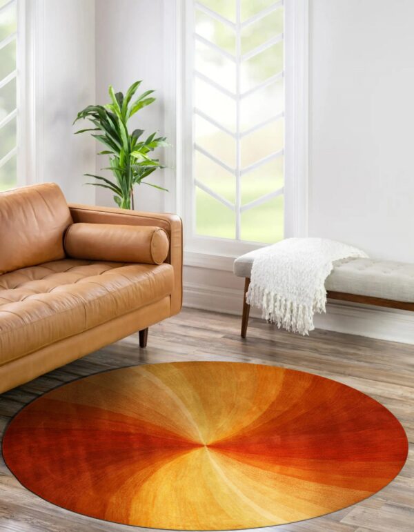 Round orange, yellow, and red rug with a radial pattern next to a tan leather sofa.