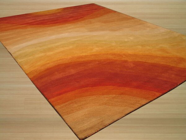 Rectangular area rug showing abstract red, orange, and gold color bands on light wood flooring.