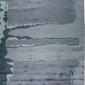 Shaggy gray rug with an abstract pattern of irregular horizontal bands in varying shades.