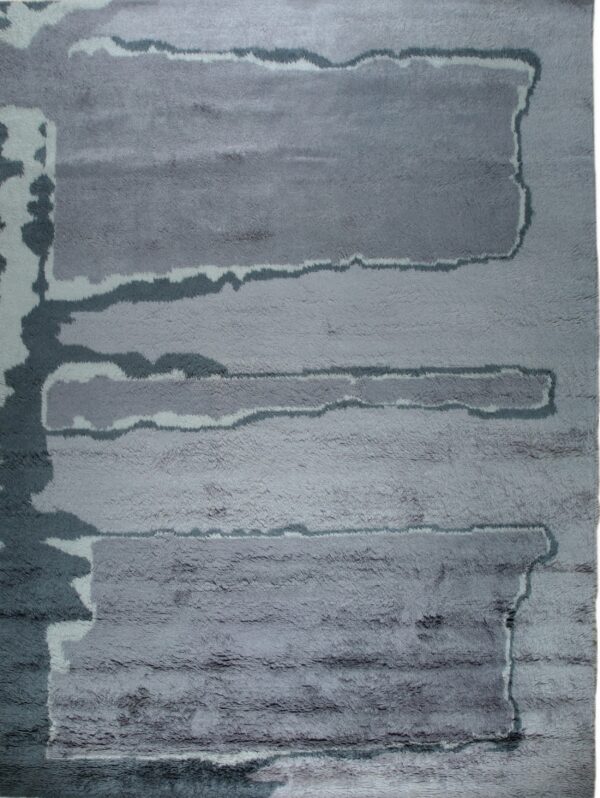 Shaggy gray rug with an abstract pattern of irregular horizontal bands in varying shades.