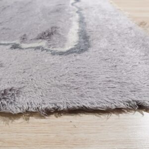 Detail view of a gray shaggy rug showing long pile, abstract curves, and light wood planks.