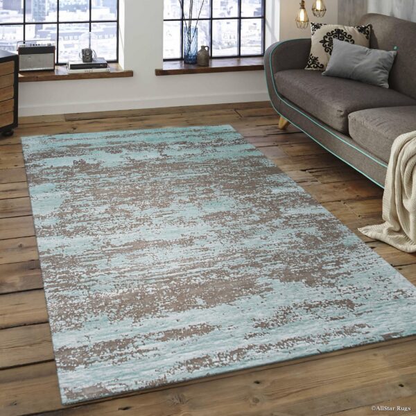 Abstract blue and brown area rug with a distressed pattern on wide plank wood flooring.